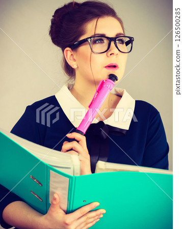 woman thinking holds file folder with documents woman thinking holds file folder with documents 126500285