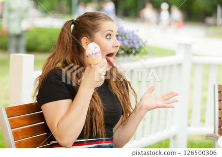Young woman eating ice cream Young woman eating ice cream 126500306