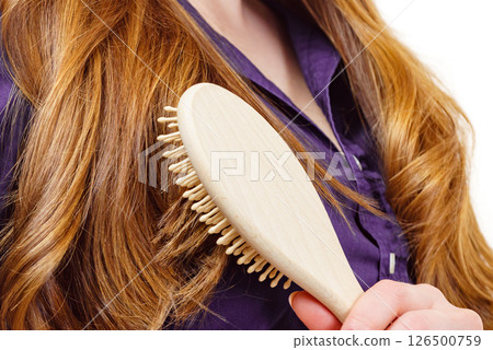 Woman brushing long healthy brown hair Woman brushing long healthy brown hair 126500759