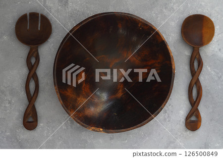 Empty round handcrafted brown wooden plate on stone concrete background, top view 126500849