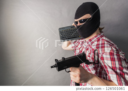 Man wearing balaclava shooting from gun 126501061