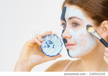 Girl black mask on half face apply white mud 126501242