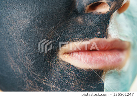Girl black and green mud mask on face 126501247