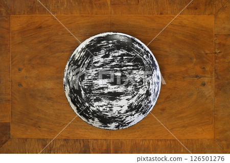 Empty black plate on wooden table. Food background for menu. Flatlay, top view. 126501276
