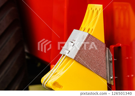 Yellow brake stop blocks wedges on red tractor 126501340