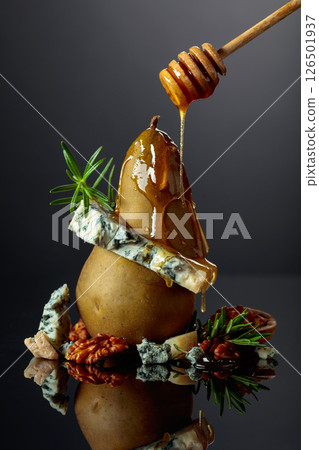 Blue cheese with honey, pear, walnuts, and rosemary on a black background. Blue cheese with honey, pear, walnuts, and rosemary on a black background. 126501937