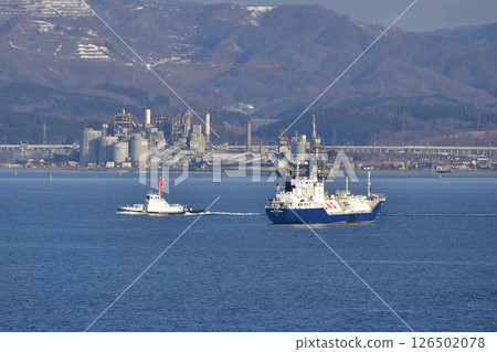 A tugboat is seen picking up a cargo ship and a cruise ship anchored in Hakodate Bay in spring in Hakodate, Hokkaido. A tugboat is seen picking up a cargo ship and a cruise ship anchored in Hakodate Bay in spring in Hakodate, Hokkaido. 126502078