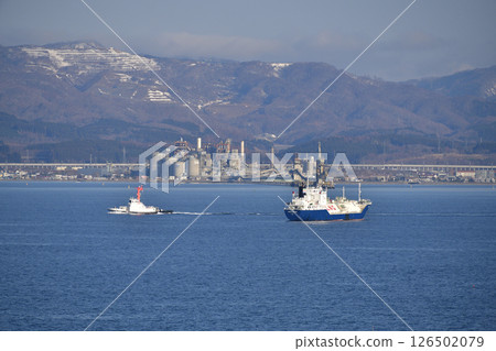 A tugboat is seen picking up a cargo ship and a cruise ship anchored in Hakodate Bay in spring in Hakodate, Hokkaido. A tugboat is seen picking up a cargo ship and a cruise ship anchored in Hakodate Bay in spring in Hakodate, Hokkaido. 126502079
