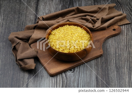 Dry bulgur wheat grains with a spoon close up Dry bulgur wheat grains with a spoon close up 126502944