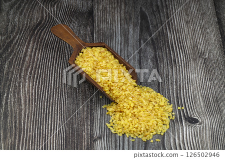 Dry bulgur wheat grains with a spoon close up Dry bulgur wheat grains with a spoon close up 126502946
