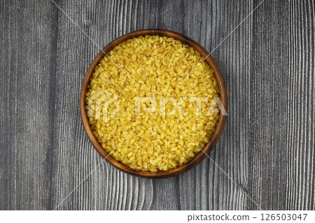 Dry bulgur wheat grains with a spoon close up Dry bulgur wheat grains with a spoon close up 126503047