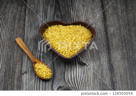 Dry bulgur wheat grains with a spoon close up Dry bulgur wheat grains with a spoon close up 126503054