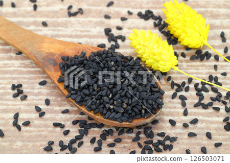 Black cumin seeds and essential oil with bowl and wooden shovel or spoon. Nigella Sativa Black cumin seeds and essential oil with bowl and wooden shovel or spoon. Nigella Sativa 126503071