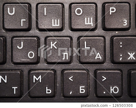 Keyboard detail featuring cyrillic and latin alphabet characters, indicating bilingual input capabilities and frequent use Keyboard detail featuring cyrillic and latin alphabet characters, indicating bilingual input capabilities and frequent use 126503308
