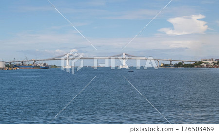 Bridge stretches across Cebu waters with boats passing below on a bright day  126503469