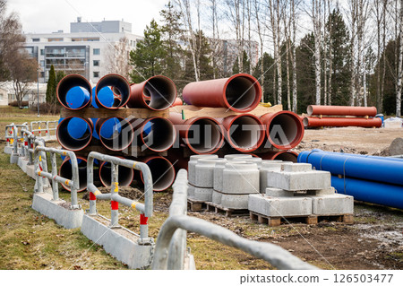 Red construction pipes stacked on wooden pallets at a construction site Red construction pipes stacked on wooden pallets at a construction site 126503477