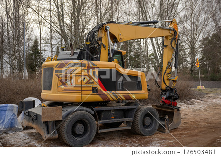 Yellow wheeled excavator with geometric patterns at construction site  126503481