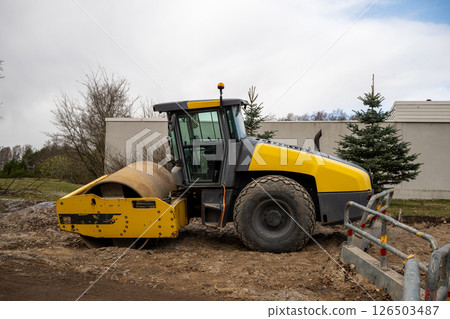 Yellow road roller parked on construction site 126503487
