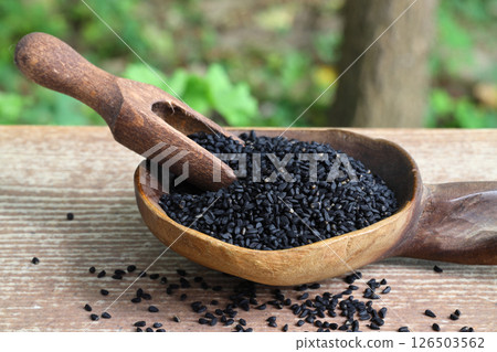 Black cumin seeds and essential oil with bowl and wooden shovel or spoon. Nigella Sativa Black cumin seeds and essential oil with bowl and wooden shovel or spoon. Nigella Sativa 126503562