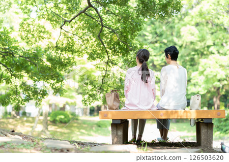 Back view of a senior woman sitting on a park bench 126503620