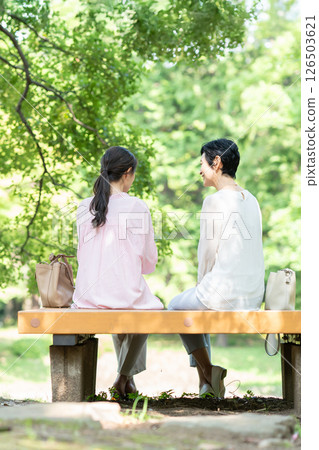 Back view of a senior woman sitting on a park bench 126503621