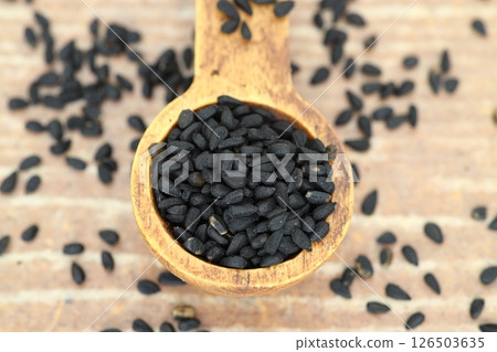 Black cumin seeds and essential oil with bowl and wooden shovel or spoon. Nigella Sativa 126503635