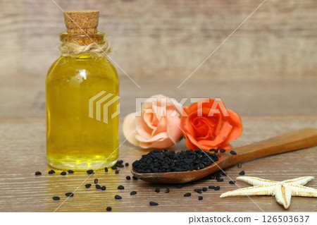 Black cumin seeds and essential oil with bowl and wooden shovel or spoon. Nigella Sativa 126503637