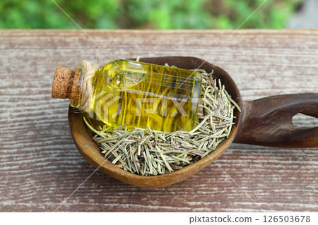 Dry organic background or texture of rosemary leaves. Healthy food concept . a wooden spoon with rosemary 126503678