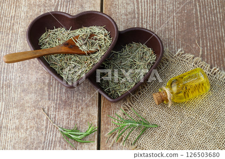 Dry organic background or texture of rosemary leaves. Healthy food concept . a wooden spoon with rosemary 126503680