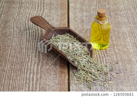 Dry organic background or texture of rosemary leaves. Healthy food concept . a wooden spoon with rosemary 126503681