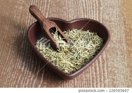 Dry organic background or texture of rosemary leaves. Healthy food concept . a wooden spoon with rosemary 126503687
