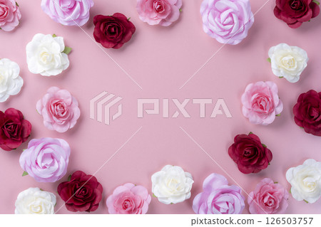 Colorful artificial roses arranged on a pink background with copy space 126503757