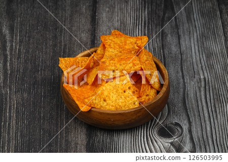 Nachos in a wooden bowl. Tortilla chips on wooden background. Nachos in a wooden bowl. Tortilla chips on wooden background. 126503995