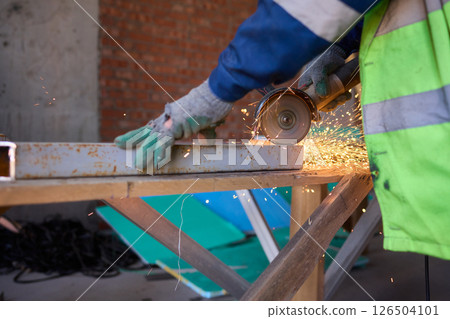 A Worker Skillfully Cutting Material with an Angle Grinder, Sparks Flying Everywhere 126504101