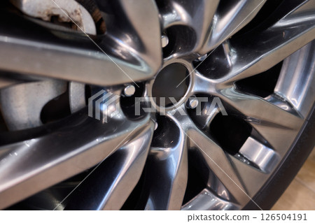 Detailed shot of a sleek black and silver alloy wheel on a motor vehicle 126504191