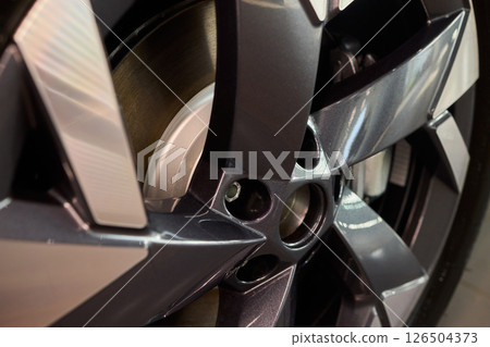 Detailed shot of a sleek black and silver alloy wheel on a motor vehicle 126504373
