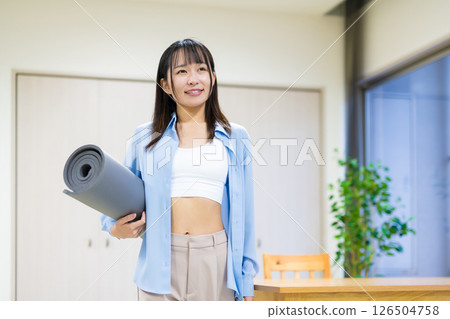 身穿休閒服、裸露腹部、手拿瑜珈墊的年輕女子瑜珈伸展飲食健康 126504758