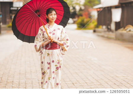 秋季中旬，一位身穿浴衣的年輕女子在雨中穿過溫泉小鎮。 [拍攝合作：新發田市電影委員會] 126505051