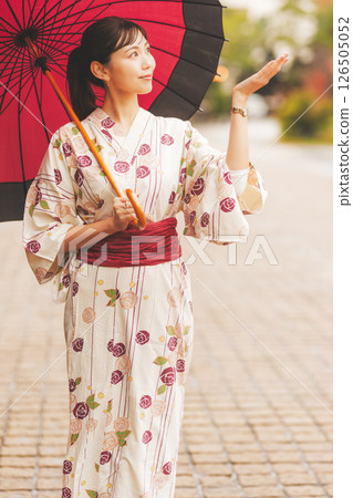 秋季中旬，一位身穿浴衣的年輕女子在雨中穿過溫泉小鎮。 [拍攝合作：新發田市電影委員會] 126505052