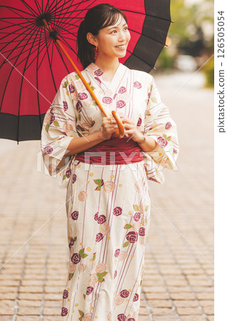 秋季中旬，一位身穿浴衣的年輕女子在雨中穿過溫泉小鎮。 [拍攝合作：新發田市電影委員會] 126505054