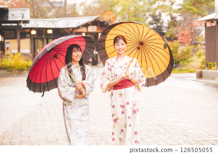 秋季中旬，一位身穿浴衣的年輕女子在雨中穿過溫泉小鎮。 [拍攝合作：新發田市電影委員會] 126505055