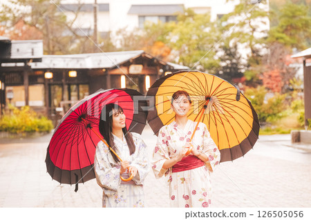 秋季中旬，一位身穿浴衣的年輕女子在雨中穿過溫泉小鎮。 [拍攝合作：新發田市電影委員會] 126505056