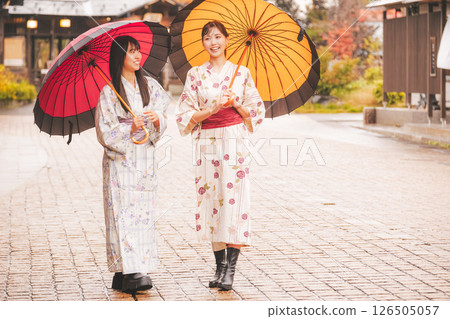 秋季中旬，一位身穿浴衣的年輕女子在雨中穿過溫泉小鎮。 [拍攝合作：新發田市電影委員會] 126505057