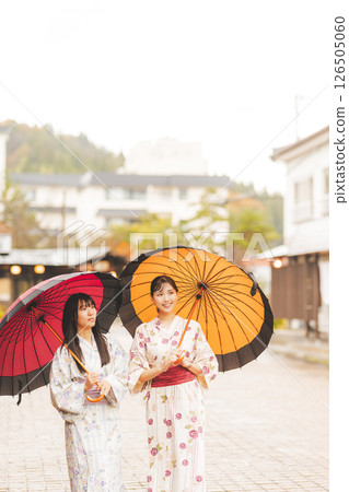 秋季中旬，一位身穿浴衣的年輕女子在雨中穿過溫泉小鎮。 [拍攝合作：新發田市電影委員會] 126505060