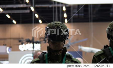 Soldiers display cutting-edge gear and firearms at a global defense event, emphasizing innovations in military technology and contemporary warfare strategies. 126505917