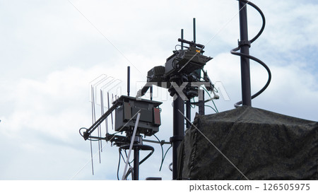 Military personnel operate advanced communication equipment atop a tower in a conflict area, enhancing coordination and tactical responses during wartime operations. Military personnel operate advanced communication equipment atop a tower in a conflict area, enhancing coordination and tactical responses during wartime operations. 126505975