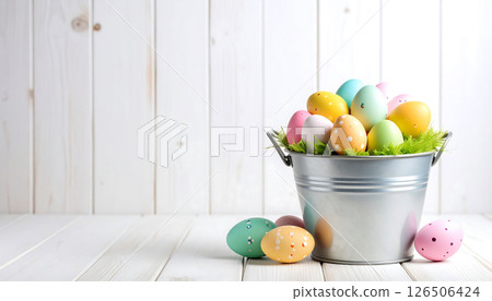 Colorful Easter eggs in a metal bucket and scattered on a white wooden surface. Festive spring decoration. 126506424