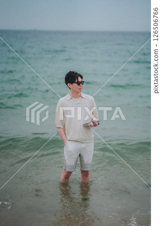 一名男子在度假村的海灘上使用平板電腦 一名男子在度假村的海灘上使用平板電腦 126506766