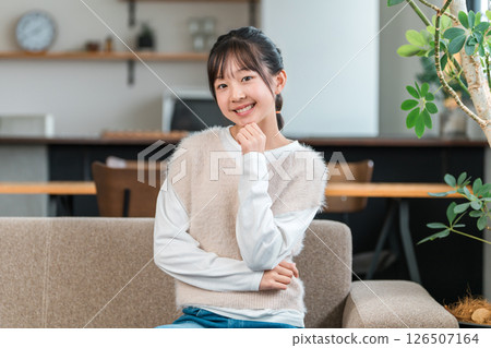 Smiling child, girl sitting on the sofa in her home (thinking, inspiration, idea, imagination) 126507164