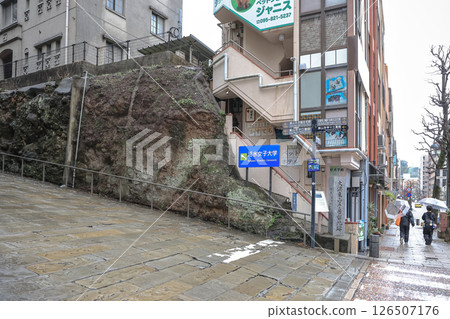 March 28 2025 City Street with Stairs and Pedestrians in Urban Rainy Setting 126507176